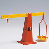 The picture shows a red beam balance with a yellow platform on one side and a weight on the other. This balance is often used in education to demonstrate principles of weight measurement and balance.