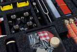 The picture shows an overview of experimental accessories organized in a logical foam insert. It contains various materials such as electrical connectors, screws, pieces of wood and other components for experiments.