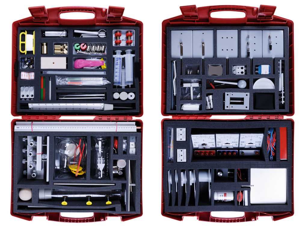 The picture shows a red toolbox filled with various experimental materials for educational purposes. The compartments contain measuring instruments, accessories, pipettes and mechanical components that can be used for scientific experiments.