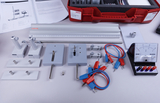 The picture shows a collection of experimental materials used for physics teaching purposes. The items shown include measuring instruments, connecting cables and various holders.