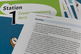 The picture shows materials for an experimental room concept that deals with the topic of air. A worksheet explains the concept of storytelling as a teaching and learning method to promote understanding of scientific phenomena.