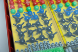 The image shows a collection of colorful plastic balls and connectors arranged in a sturdy container. These items are likely used to represent chemical structures and molecules in an educational setting.