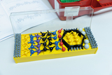 The picture shows a molecular construction kit consisting of various colorful plastic balls and connecting elements. It lies on a table surrounded by teaching materials and is designed for experimental purposes in education.