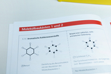 The image shows a page from a molecular modeling textbook dealing with aromatic and non-aromatic hydrocarbons. Chemical structures of benzene and cyclohexane are shown, along with explanations of their properties.