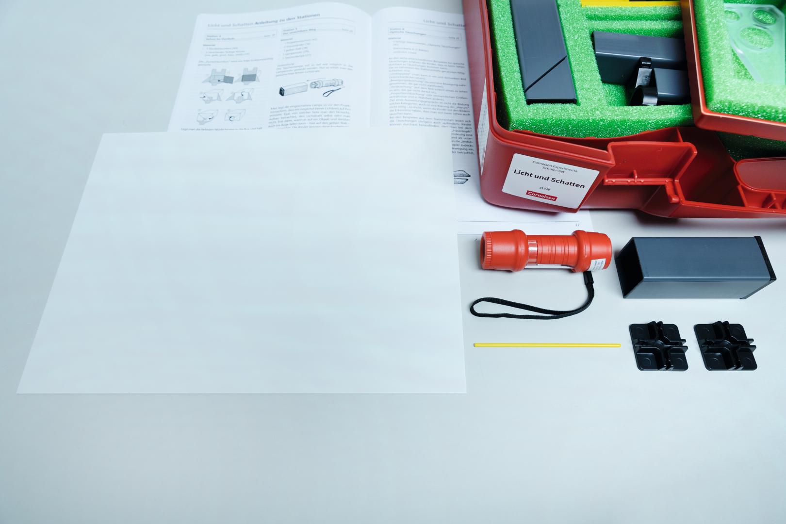 The picture shows an experiment box with the theme &quot;light and shadow&quot;. The box contains various materials such as a flashlight, individual parts and instructions that can be used for experiments on lighting.