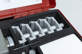 The image shows a red storage kit with several silver components placed in a padded foam insert. The parts appear to be designed for experimental purposes in education, possibly for conducting physics or engineering experiments.