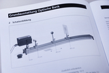 The image shows an illustration of an optical bench for demonstrating shadow formation. Various components are shown, including a lamp and objects used to create and study shadows.