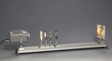 The picture shows an experimental device with a projector that uses several transparent foils to demonstrate light refraction and reflection. The foils are mounted on a rail and enable various optical experiments in the educational field.