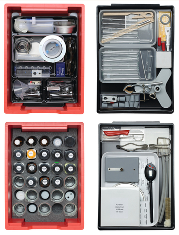 The picture shows different types of experimental materials in several boxes. In the boxes, utensils such as test tubes, pipettes, chemicals and measuring devices are clearly arranged and ready for use in education.