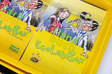 The picture shows a yellow box with instructions for the &quot;EcoLabBox&quot;, which is intended for experiments in education. The cover shows cartoon-like figures conducting a scientific investigation.