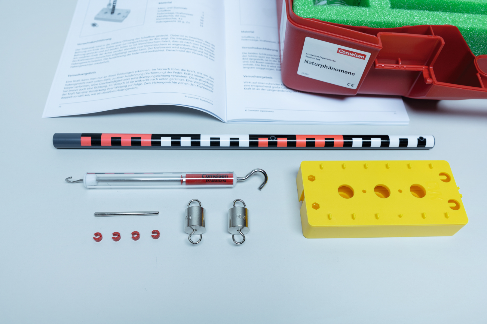 The picture shows an experimental set with various components such as a color-coded rod, a container and several small accessories. It also shows instructions for carrying out experiments to illustrate natural phenomena.