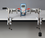 The picture shows two motors mounted on a table, connected to a measuring device. One of the motors has a weight hanging from it, which can be used for experiments investigating mechanical energy or torque.