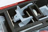 The image shows a collection of experimental equipment housed in a black foam box insert. The equipment appears to be designed for physics experiments and includes, among other things, some kind of holding device and a pulley.
