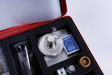 The picture shows an experiment kit that contains a variety of laboratory equipment, including a small burner, a glass jar, and a box of matches. The components are neatly arranged in a padded container that allows for easy transport.