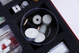 The picture shows a storage unit with various materials that can be used for experiments. It contains, among other things, candles, grey pipes and yarn, which are suitable for different experimental purposes.