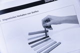 The picture shows a hand holding an elongated object over a series of differently colored rods. The title of the section is &quot;Magnetic Behavior of Materials,&quot; which indicates an experiment on magnetization.