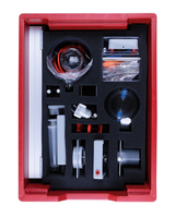 The picture shows a red box equipped with various experimental materials, including glasses, adapters and various technical components, all neatly arranged in foam padding. This set is used to carry out experimental projects in the educational sector.