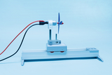 The picture shows an experimental device with a small propeller on a sled mounted on an aluminum rail. The red and black wires indicate that the device is electrically powered, probably for physics experiments.