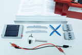 The picture shows various components of an energy conversion experiment kit, including a solar panel, a propeller shaft and connecting elements. There are also instructions on how to carry out experiments on a sheet of paper.