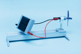 The picture shows a solar panel connected to a motor and a propeller, all mounted on a stable base. It is an experimental device used to demonstrate solar energy and mechanical movement.