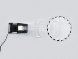 The picture shows an optical experimental device with a light emitter that is passed through a lens. Next to the lens is a rotated scale that is used to analyze the light rays and their refraction.