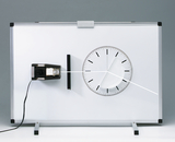The picture shows an experimental device used to illustrate physical principles. It consists of a white board with a scale and a moving line, probably used to measure angles or movements.