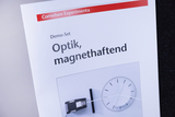 The image shows a catalog entry for an optics demo set entitled &quot;Optics, magnetic&quot;. It contains an illustration of an optical experiment that may serve as a learning aid for the German educational system.