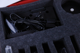 The picture shows a padded box with various cables and an electrical component. The components are neatly laid out in foam, indicating a need for protection during transport.