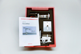 The picture shows a student set called &quot;DynaMot&quot;, which is presented in a red plastic box. In addition to various components, there are instructions that describe how to use the set for experiments in the educational field.