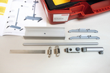 The picture shows various components of an experiment kit called &quot;Mechanics 2.0&quot;, which is intended for use in education. Next to the kit, you can see assembly instructions and numerous metal and plastic parts for carrying out mechanical experiments.