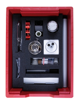 The picture shows a red box equipped with various experimental materials, including glassware, a syringe, and various small containers. All utensils are safely placed in foam to protect them during transport.