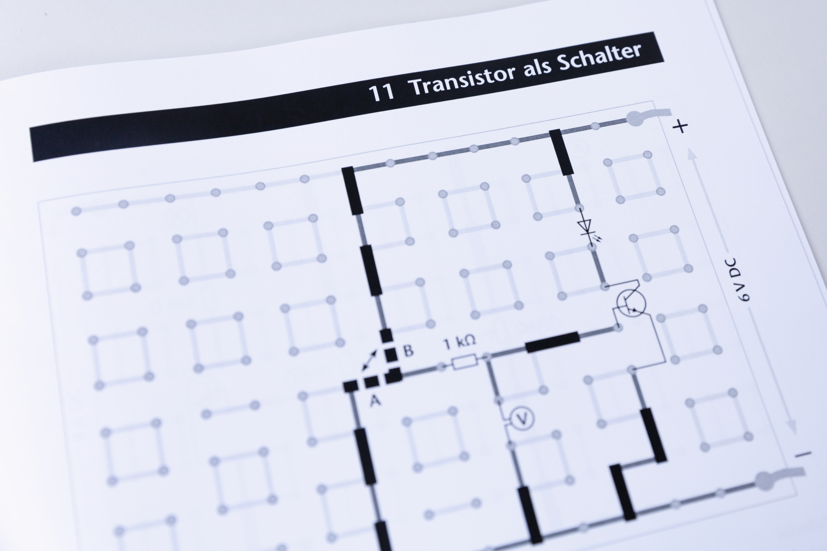 The picture shows a circuit diagram for using a transistor as a switch, with various components and connecting lines. It contains information on resistance values and voltage supply, which are important for experiments in the educational field.