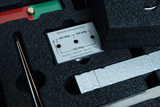 The picture shows a device with a plaque containing technical specifications for electrical experiments. It is housed in a foam-padded container, presumably intended for safe transport and storage.