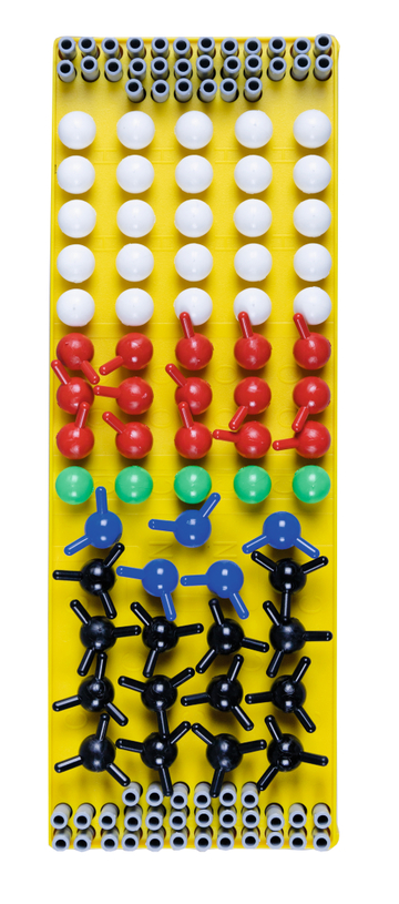 The picture shows a clear arrangement of colorful model blocks that represent different atoms and molecules. The blocks are arranged on a yellow plate and serve as learning material for experiments in education.