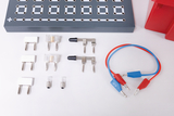 The picture shows a selection of experimental components, including various connectors and a circuit board with connection holes. There are also some light bulbs and colored wires that are typically used for electrical circuits.