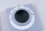 The picture shows a gray painted measuring instrument with a round scale showing angles from 0 to 90 degrees. There is an opening in the middle, possibly used for conducting experiments or measurements.