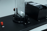 The picture shows an experimental device with a transparent chamber and a rotating element, which is apparently used for chemical or physical experiments. It is mounted on a stable platform and impresses with its technical construction.