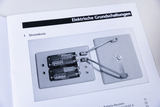 The picture shows a circuit with two batteries mounted on a plate base. The wires connect the batteries to another element to demonstrate the electrical circuit.