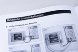 The image shows a guide to connecting batteries in series, illustrated by three different scenes with measuring devices in place. Each image demonstrates the voltage results of the circuit with different battery configurations.