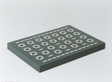 The image shows a gray platform with several rectangular contacts evenly spaced. This structure appears to be designed for experimental purposes in education, possibly for conducting electrical experiments or circuits.