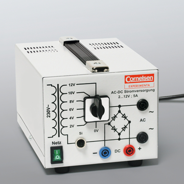 The picture shows an AC-DC power supply with a regulator for setting the voltage between 0 and 12 V and connection options for direct and alternating current. It is designed for use in educational experiments.