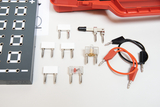 The picture shows a selection of experimental materials, including connectors and cables, intended for practical use in schools. A gray circuit board with connection holes can also be seen, indicating electromagnetic applications.
