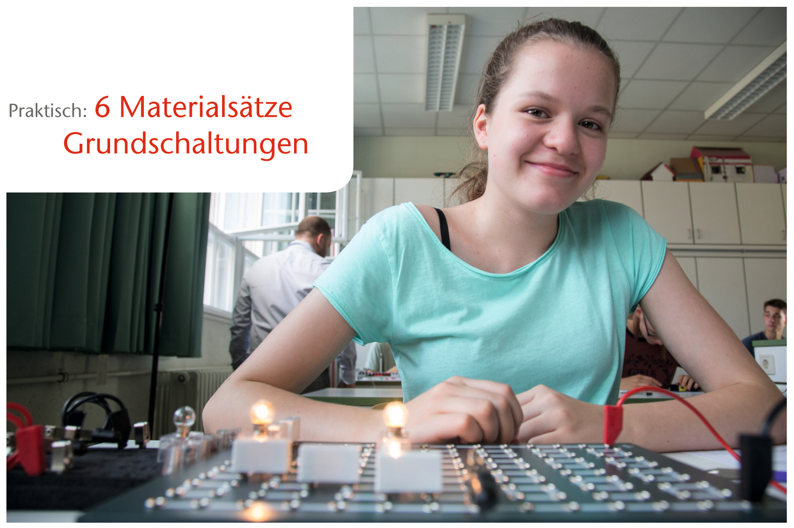 The picture shows a girl smiling as she works at a table with electrical components and circuits. In the background are other students and teachers in a classroom used for experiments.