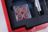 The picture shows a red storage box lined with foam and containing various experimental materials. Particularly striking are the four red compasses, which are neatly arranged in a transparent packaging.
