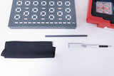 The picture shows an experiment board with several plug-in fields, a grey pen, a black cloth, a grey rod and a white holder. These materials are typical for use in education to carry out physics experiments.