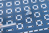 The image shows an experimental platform with a structure of silver rings and white lines, on which a circular device with a rotating element is located. A shiny metal rod is held nearby for manipulation of the experiment.