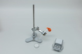 The picture shows an experimental setup with a tripod, a holder for a test tube and a small candle. Next to the setup is a digital scale that can be used to accurately measure materials during experiments.