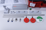 The picture shows various experimental components, including metal rods, brackets, weights and strings, that can be used for mechanical experiments. The parts are carefully arranged and provide an overview of the experimental material for the classroom.