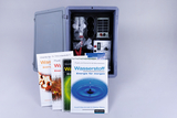 The picture shows an experiment kit that was developed for use in schools in the areas of physics and chemistry. Next to the kit are several textbooks about hydrogen and its energy potential.