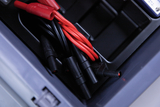 The image shows a collection of cables, including red and black connecting cables, arranged in a container. These components are typically part of experimental or measuring equipment used in education.